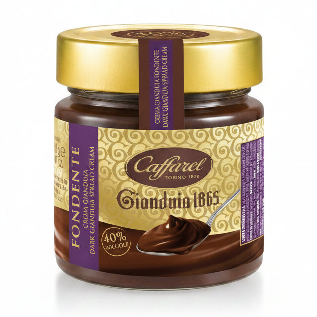 Vasetto di vetro di crema spalmabile Caffarel Gianduia 1865 Fondente con etichetta marrone e dorata con cucchiaio di cioccolato su sfondo bianco