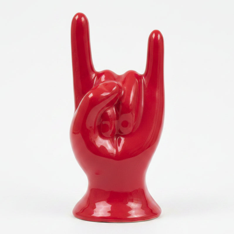 Scatola o statuetta decorativa in ceramica rossa lucida a forma di mano che fa il gesto rock su sfondo bianco