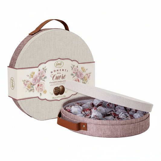 Cappelliera rotonda in tessuto con decorazione floreale a rose Feletti Momenti del Cuore, aperta con cioccolatini incartati e manico in ecopelle su sfondo bianco