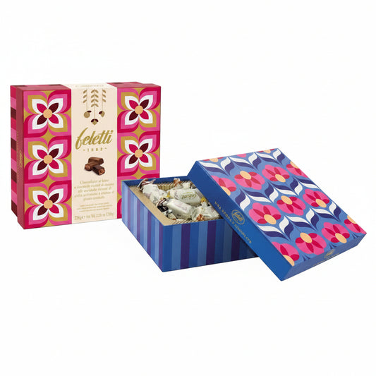 Scatola regalo Feletti da 224g con motivi geometrici e floreali in tonalità fucsia, bordeaux e blu, mostrata sia chiusa che aperta con cioccolatini all'interno su sfondo bianco