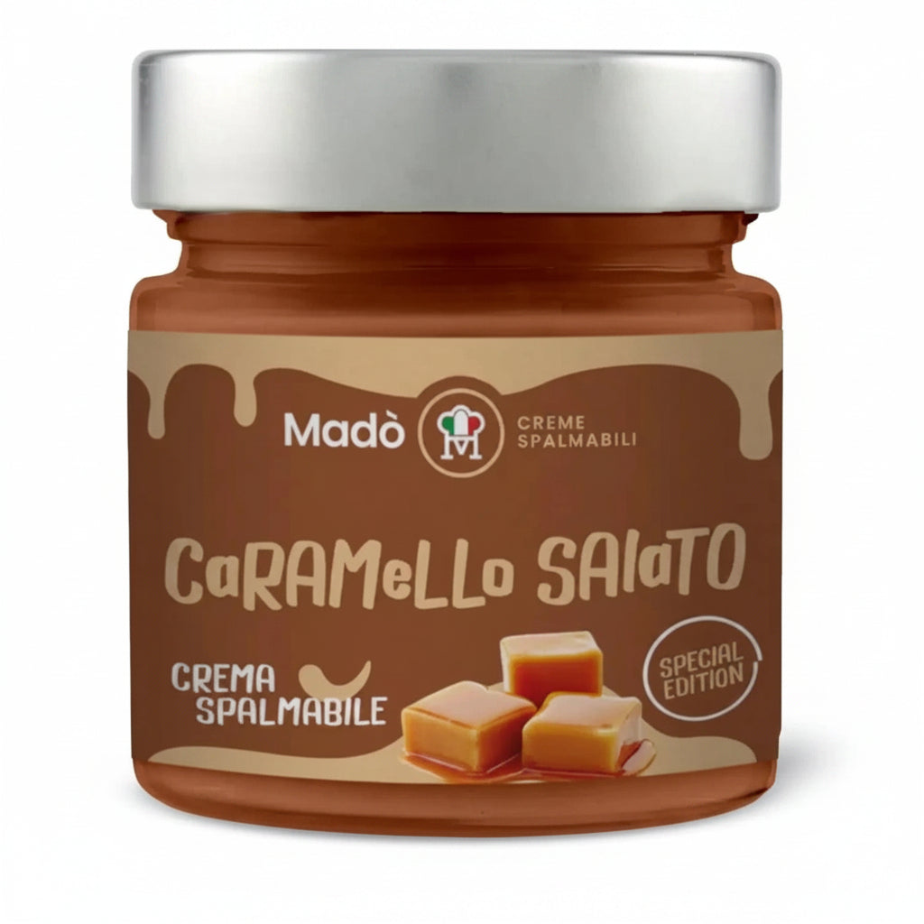 Vasetto di vetro di crema spalmabile al Caramello Salato Madò Special Edition con etichetta marrone e cubetti di caramello su sfondo bianco