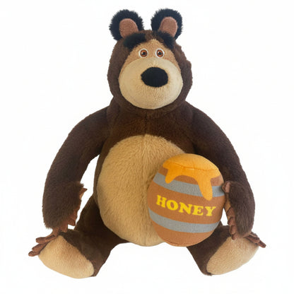 Peluche dell'Orso della serie Masha e Orso, seduto mentre tiene tra le zampe un morbido vaso di miele con la scritta "Honey"