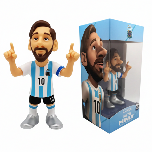Action figure da collezione Minix di Lionel Messi con la maglia dell'Argentina numero 10 e le dita puntate verso l'alto, affiancata dalla sua confezione di vendita azzurra con finestra trasparente