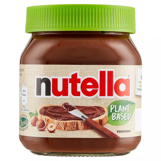 Vasetto di vetro di Nutella Plant Based Ferrero con tappo verde e scritta Plant Based sull'etichetta con pane e nocciole su sfondo bianco