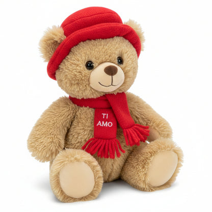 Tenero orsetto di peluche marrone chiaro seduto con cappello e sciarpa rossa con la scritta ricamata Ti Amo su sfondo bianco