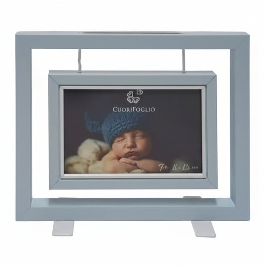 Portafoto da tavolo CuoriFoglio in legno bianco e celeste con foto di neonato e confezione originale su sfondo in legno