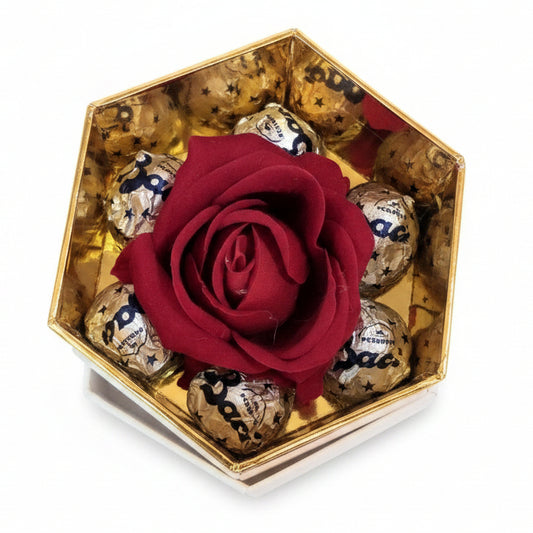 Scatola regalo esagonale con interno dorato contenente una rosa rossa centrale circondata da cioccolatini Baci Perugina su sfondo bianco