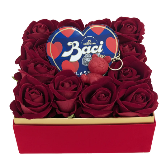 Confezione regalo con scatola a cuore Baci Perugina, rose rosse vellutate e portachiavi orsetto rosso in scatola quadrata su sfondo bianco