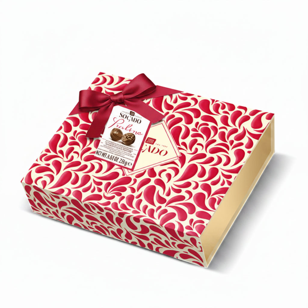 Confezione regalo quadrata Socado Praline con motivo rosso e bianco, decorata con un nastro e un fiocco in tessuto rosso su sfondo bianco